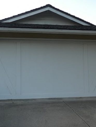 Professional garage door repair technician servicing a residential garage door in Edison, New Jersey