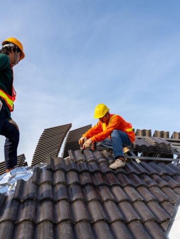 2 construction workers install new roof construction site electric drill used new roofs with concrete roof tiles concept residential building construction