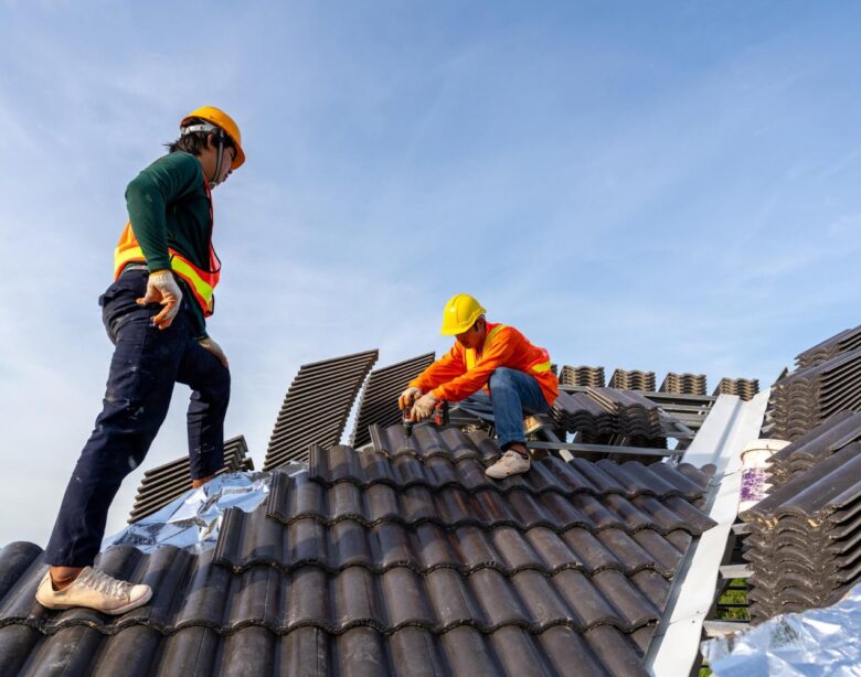 2 construction workers install new roof construction site electric drill used new roofs with concrete roof tiles concept residential building construction