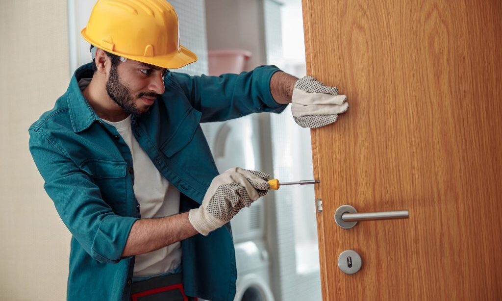 locksmith workman in uniform installing door knob 2023 01 05 00 20 11 utc